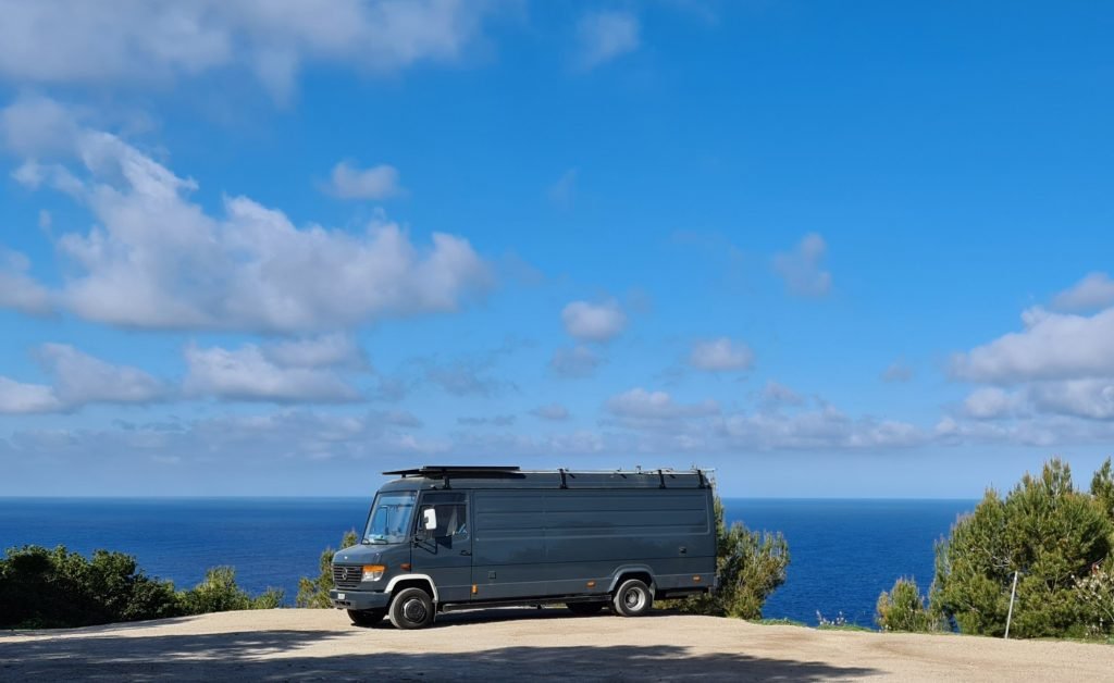 Campervan parked in a scenic spot in front of the sea