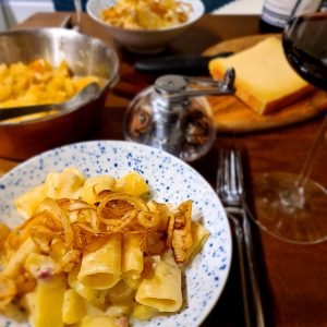 dish of cooked pasta with bacon in a cheese sauce, topped with crispy onions