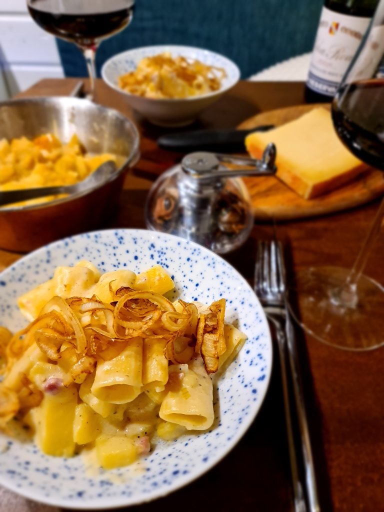 dish of cooked pasta with bacon in a cheese sauce, topped with crispy onions