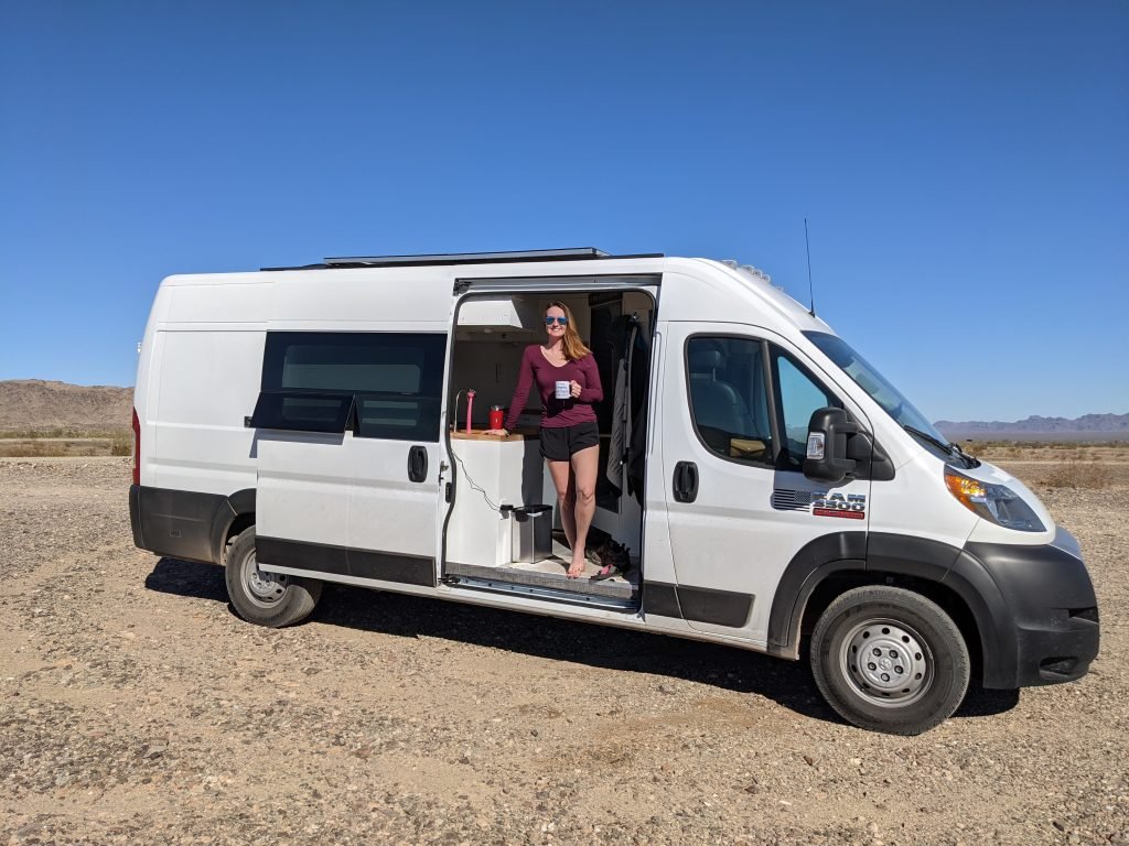 Woman standing in doorway of her campervan