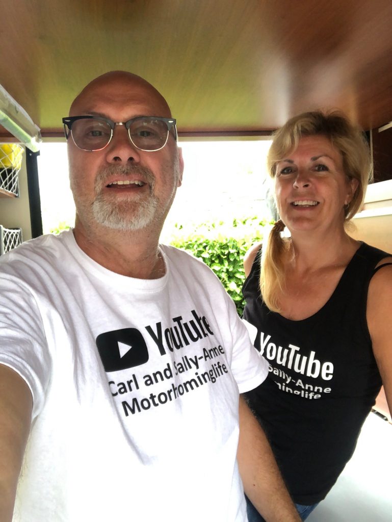 Carl and Sally-Anne in their motorhome wearing their YouTube branded tops