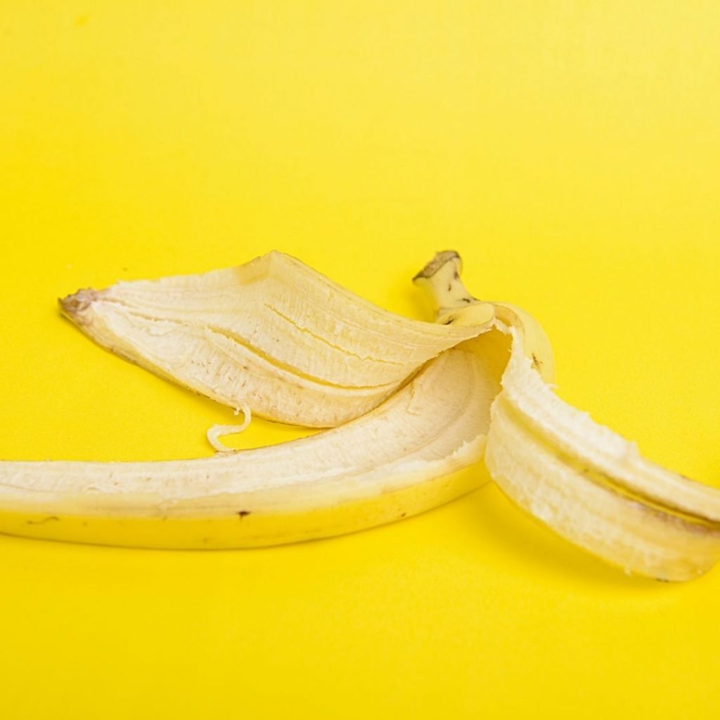 Banana peel on bright yellow background