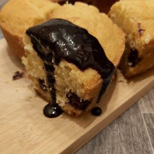 Sponge cake with blackberry coulis dripping down the sides