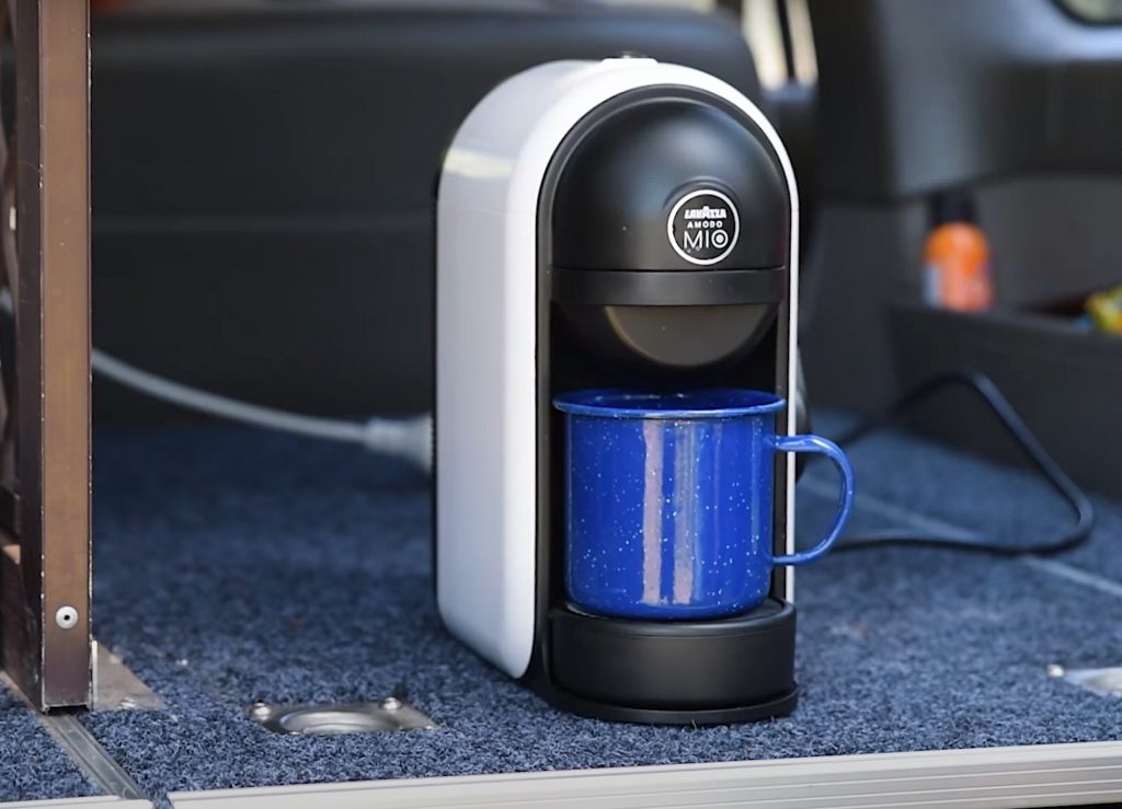 Photo of a small coffee machine on the floor of a van