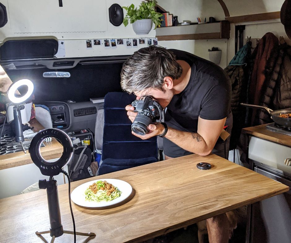 Andy photographing a plate of food in the bus for the cookbook.